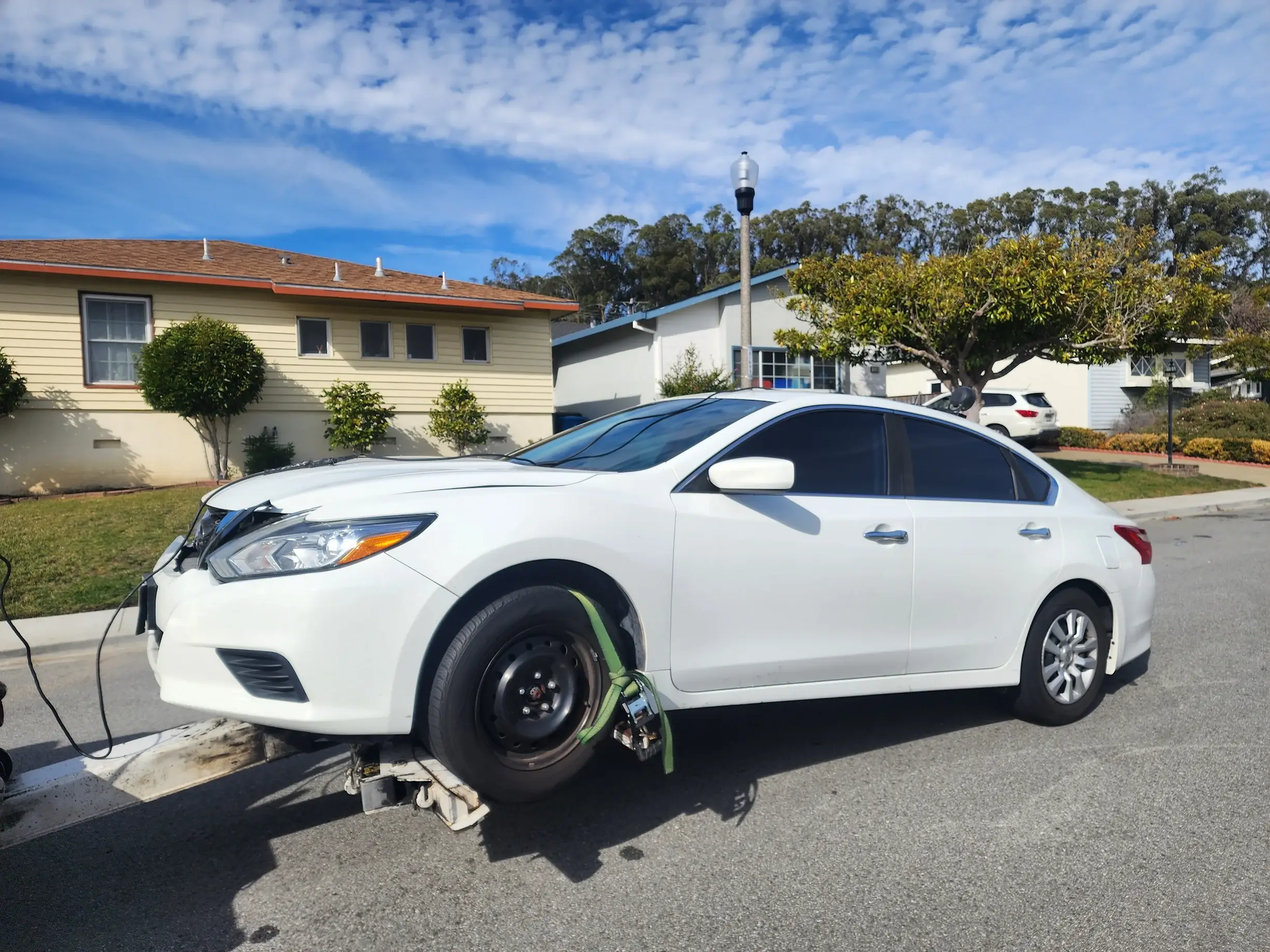 A white car that is sitting in the street.
