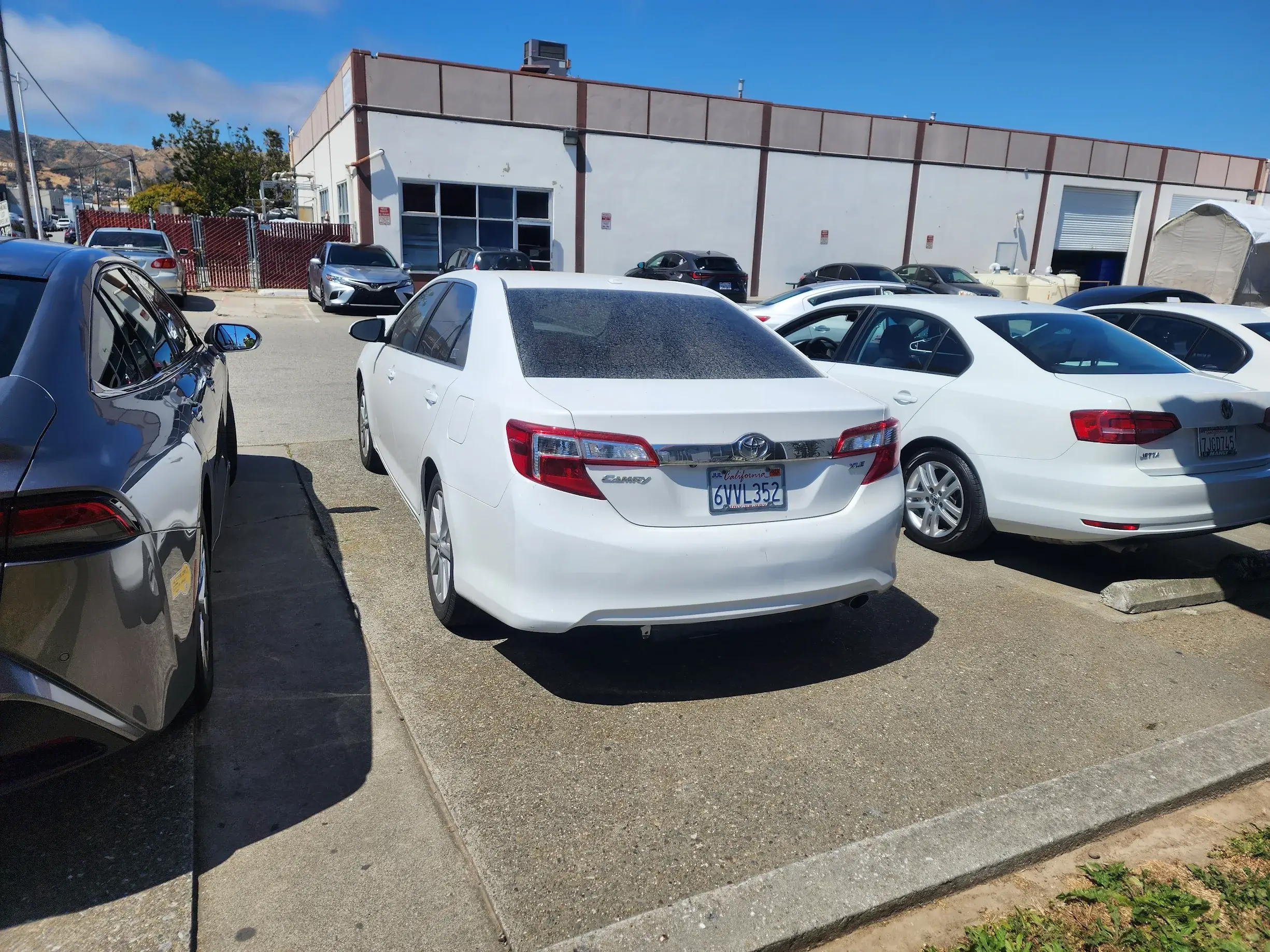 A white car parked in the middle of a parking lot.
