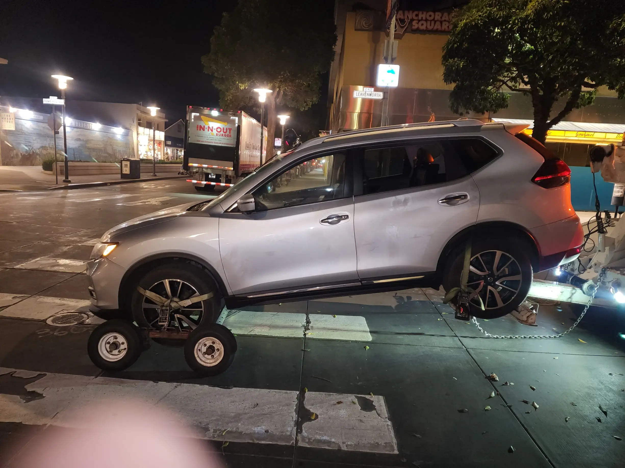 A silver car with wheels on the ground