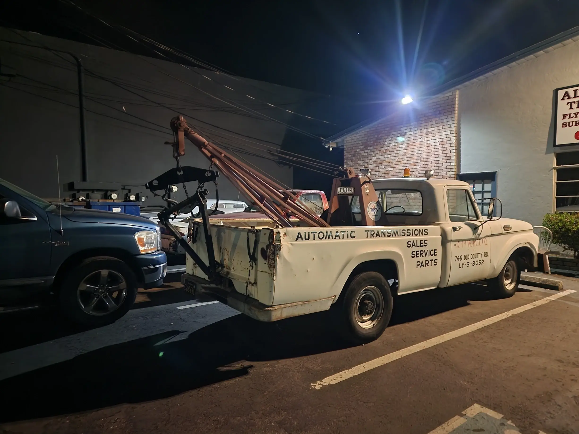 A tow truck is parked in the dark.