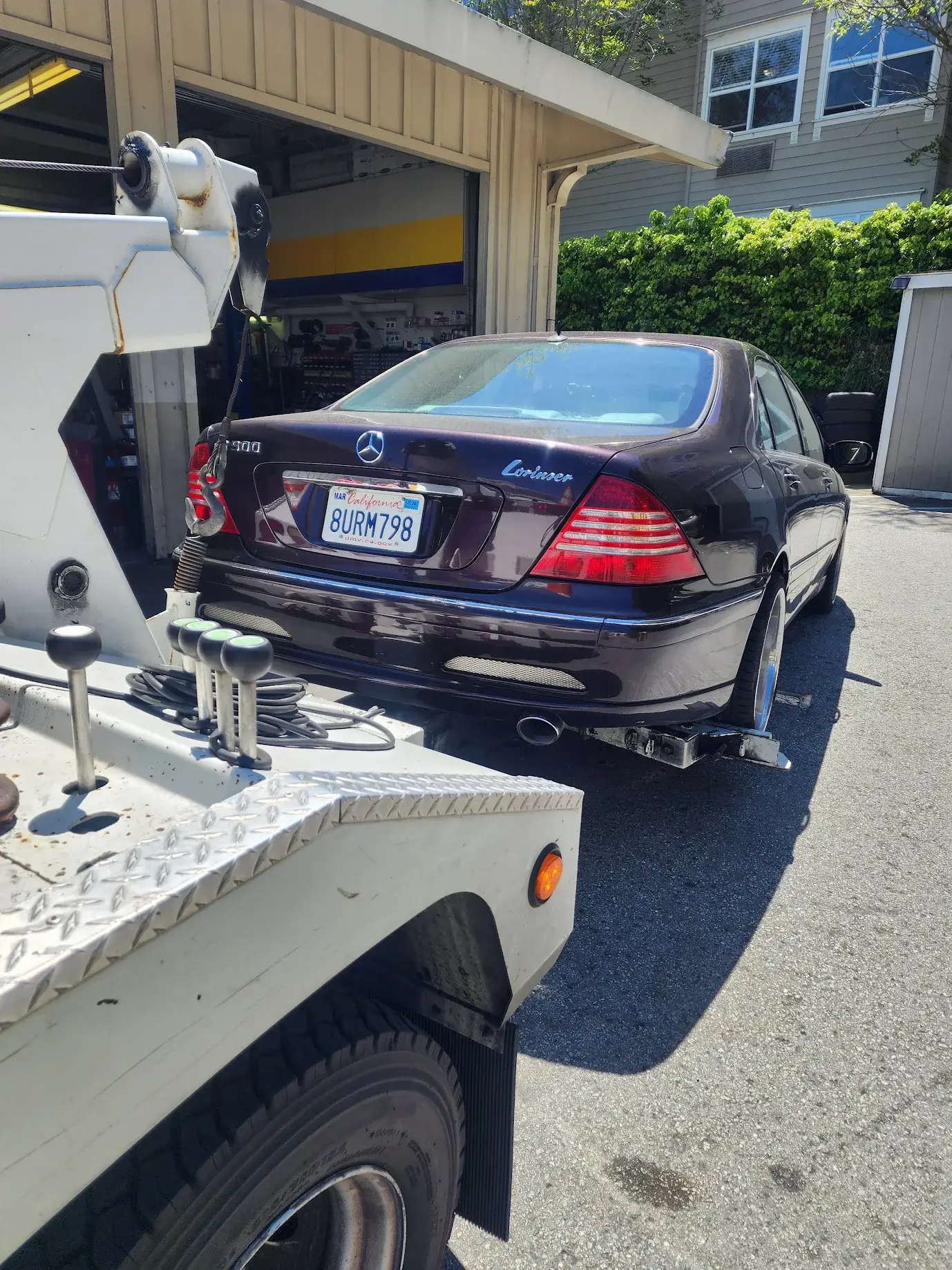A tow truck towing a car behind it.
