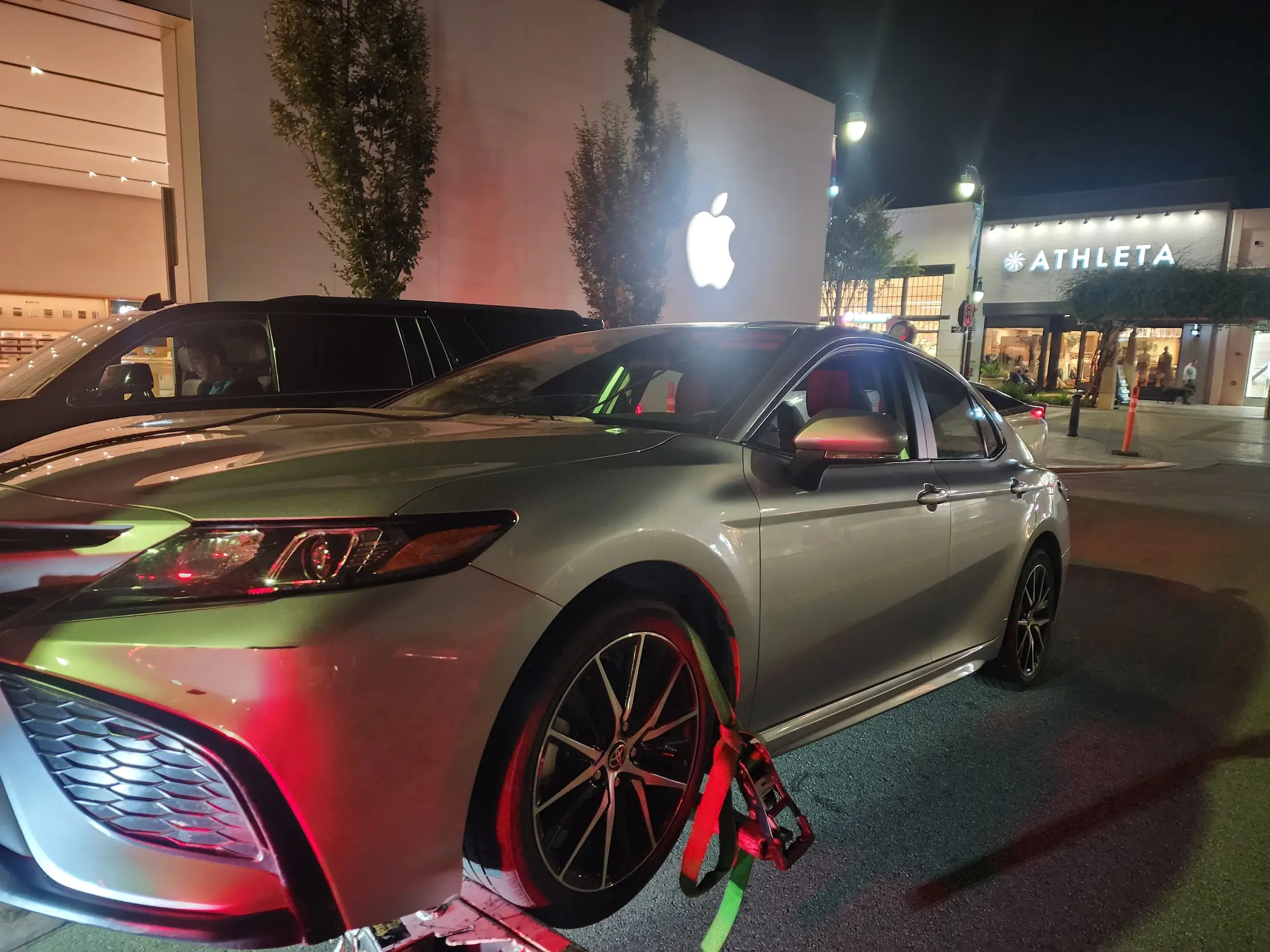 A silver car parked on the side of a street.