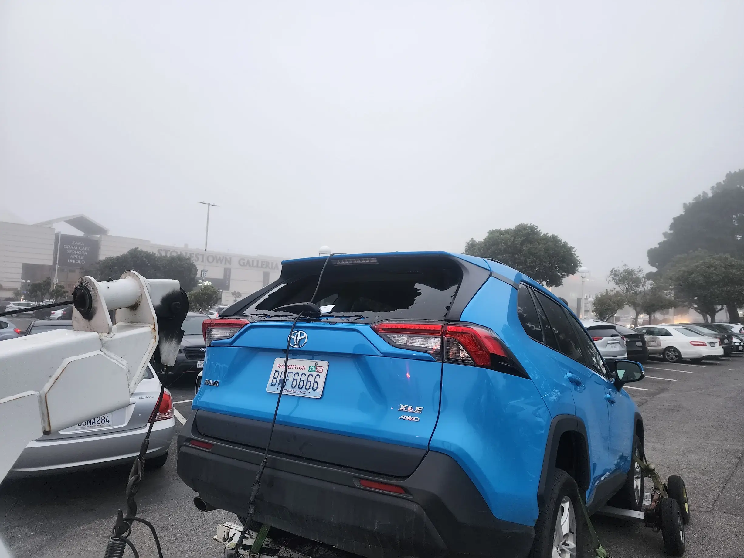 A blue suv is parked in the middle of a street.