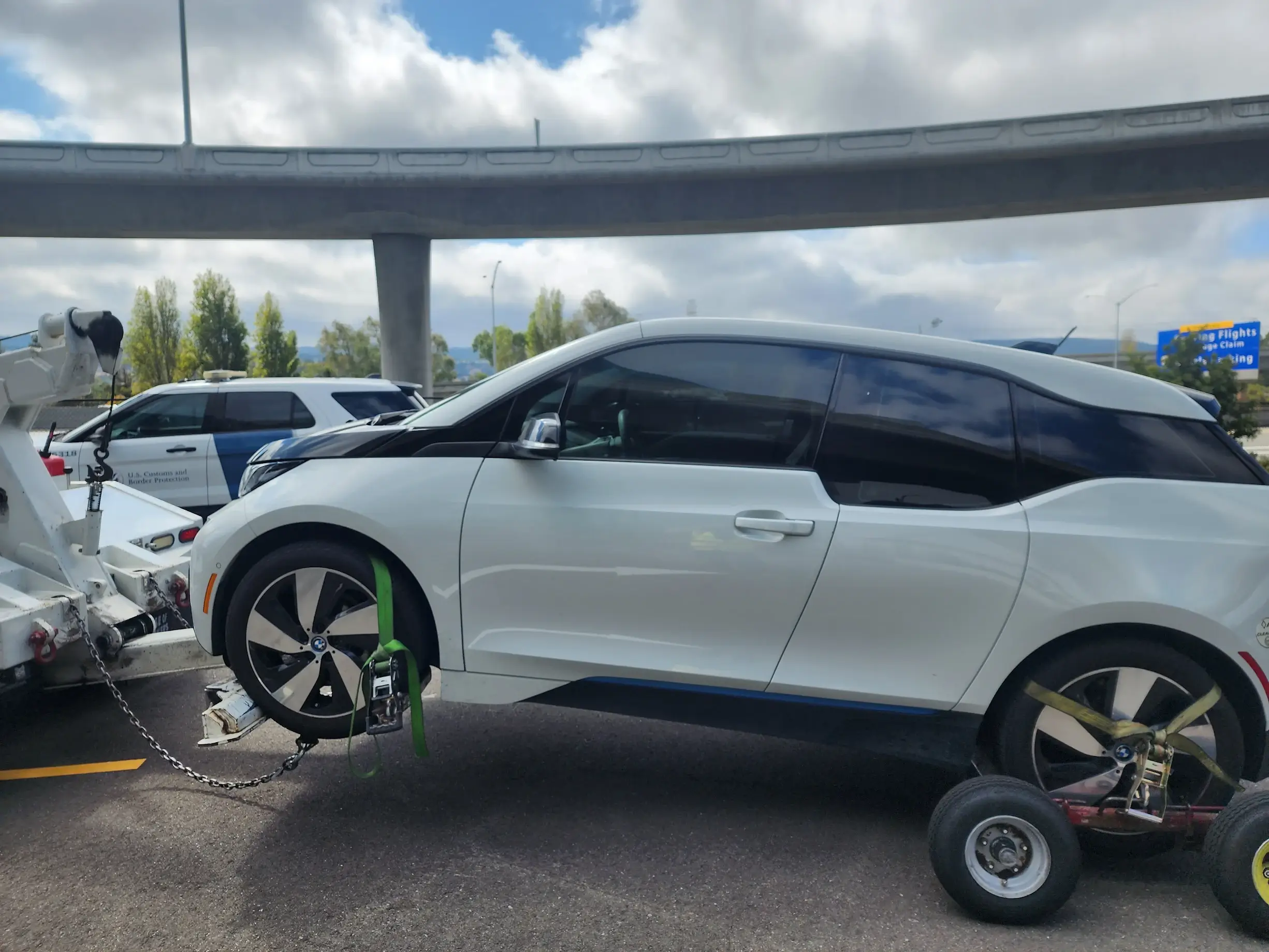 A white car with a wheel on it's side.
