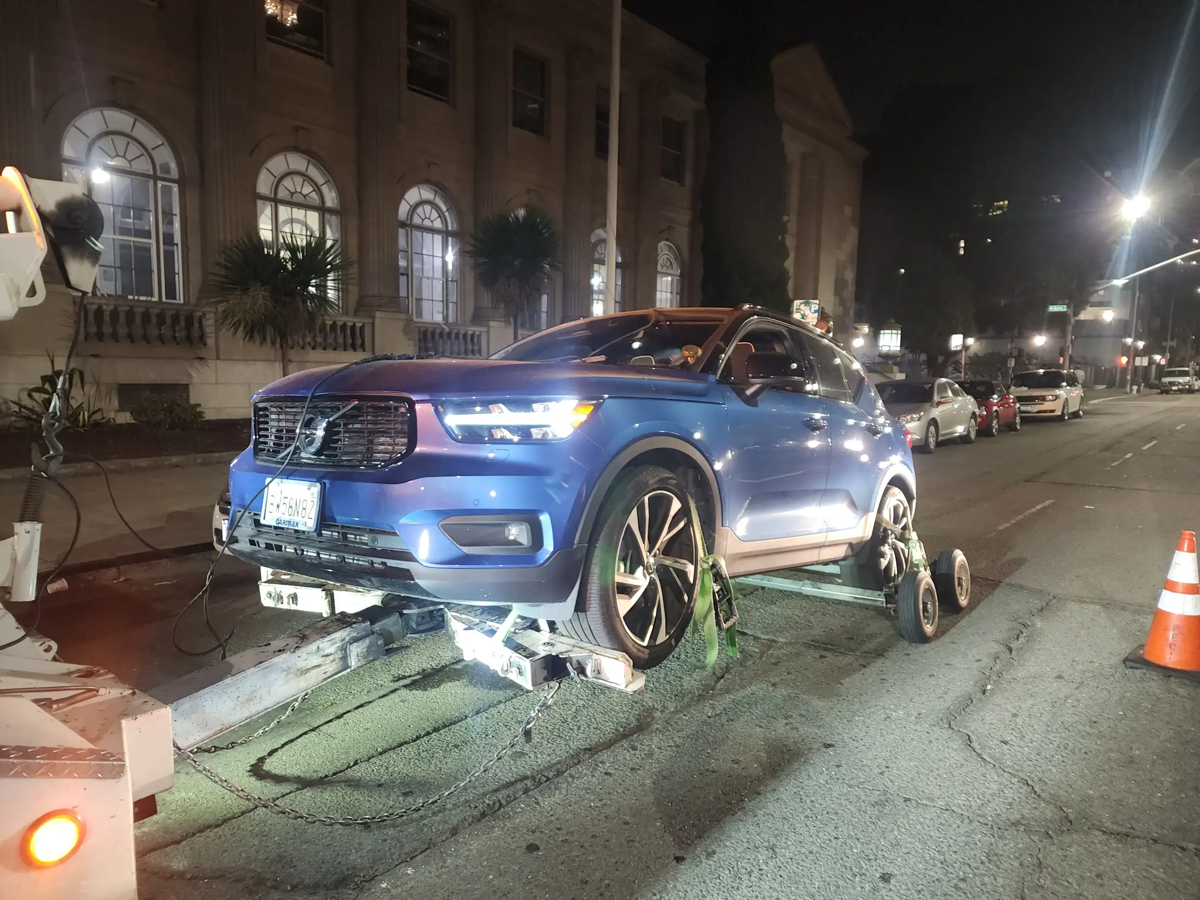 A blue car that is on the side of the road.