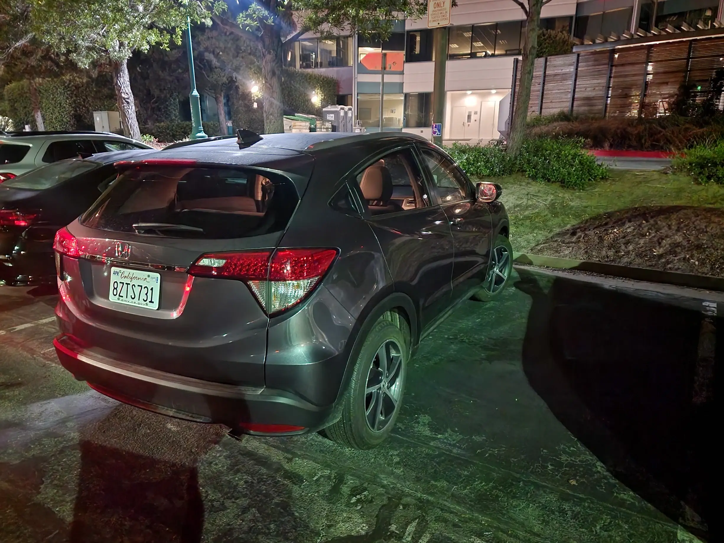 A car parked in the grass at night.